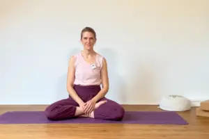 Die Yogalehrerin Anna Sophie Pietsch sitzt auf einer Yogamatte und begrüßt die Teilnehmerinnen ihrer Online-Membership