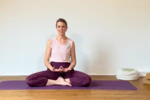 Die Yogalehrerin Anna Sophie Pietsch sitzt auf einer Yogamatte und begrüßt die Teilnehmerinnen ihrer Online-Membership