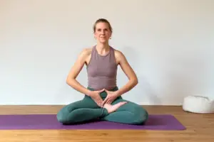 Die Yogalehrerin Anna Sophie Pietsch sitzt auf einer Yogamatte leitet eine Visualisierung an