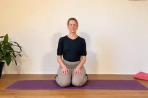 Die Yogalehrerin Anna in einer Beckenboden Meditation.